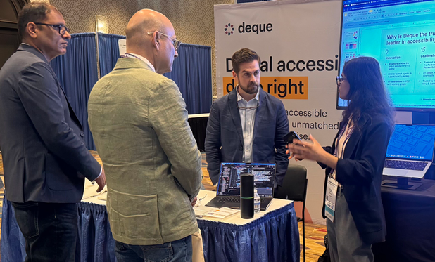 Deque staff and M-Enabling attendees discuss accessibility automation at the Deque branded booth.